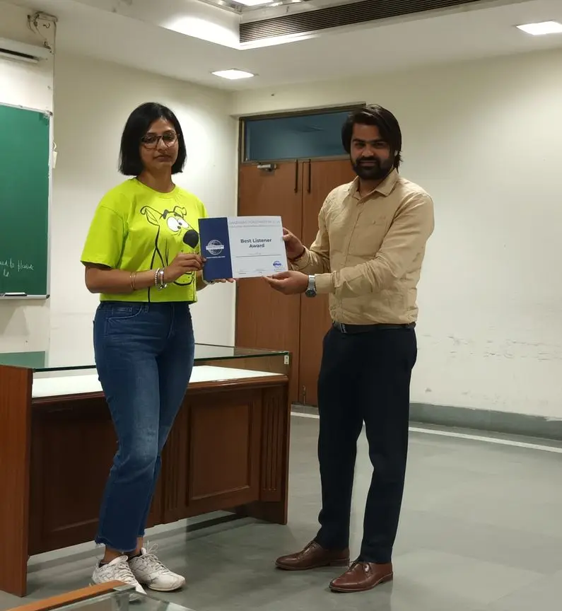 Toastmasters member receiving award, public speaking achievement.