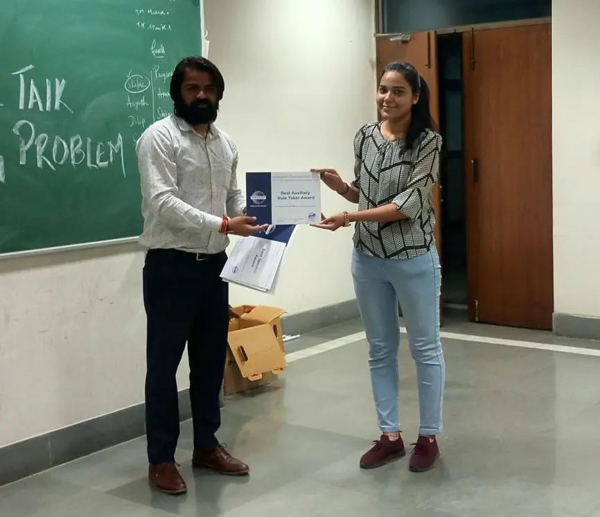 Toastmasters member receiving award, public speaking achievement.