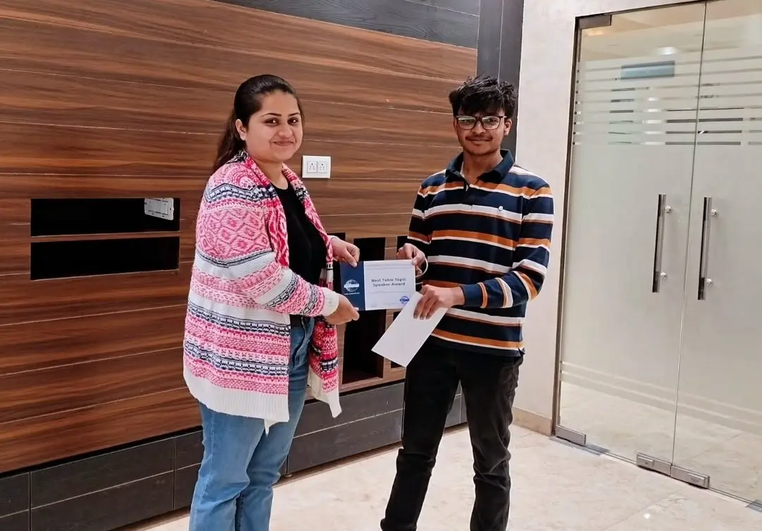 Toastmasters member receiving award, public speaking achievement.