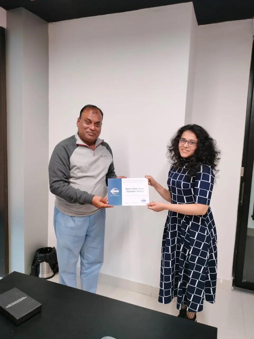 Toastmasters member receiving award, public speaking achievement.